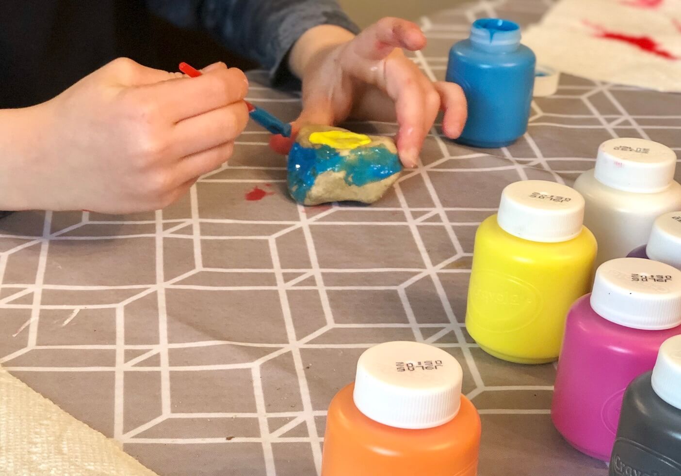 boy-painting-colorful-rocks-for-art-class-at-homes-2022-11-15-12-41-55-utc.jpg